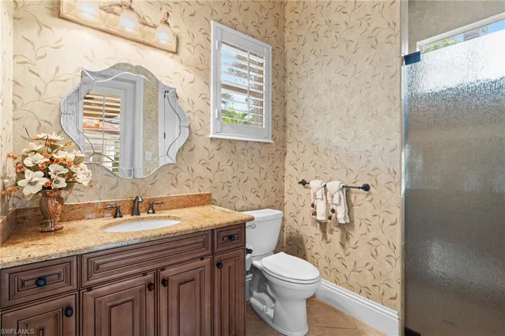 Bathroom featuring toilet, tile patterned flooring, and vanity