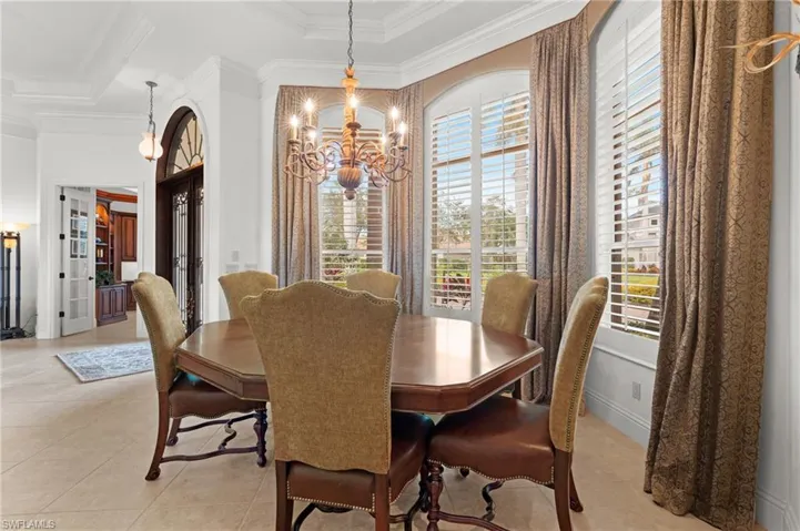 Tiled dining area with ornamental molding and a chandelier