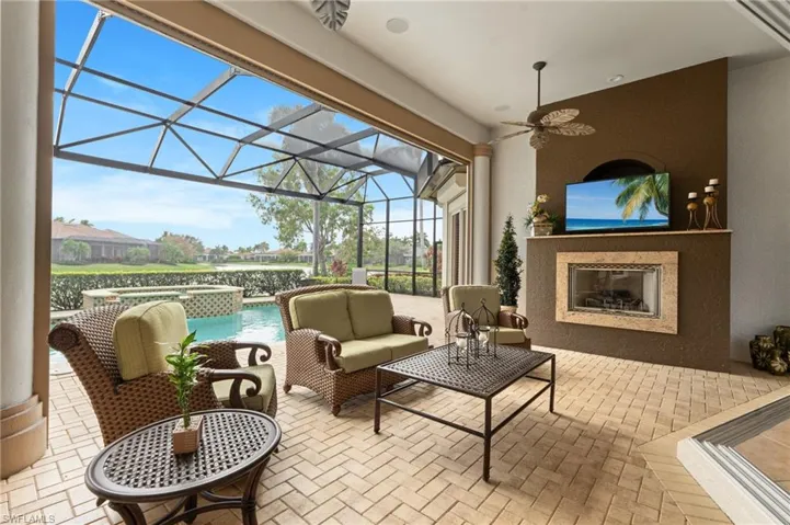 View of patio featuring glass enclosure and an outdoor living space with a fireplace