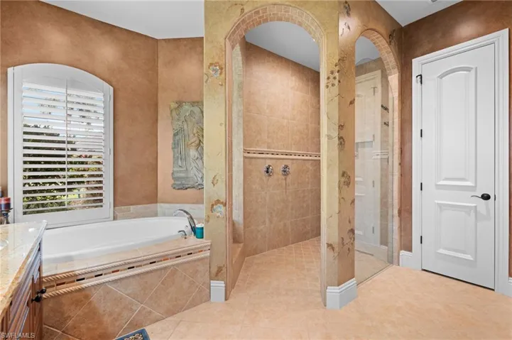 Bathroom featuring vanity, tile patterned flooring, and plus walk in shower