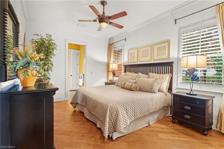 Bedroom with ceiling fan, ornamental molding, light hardwood / wood-style floors, and multiple windows
