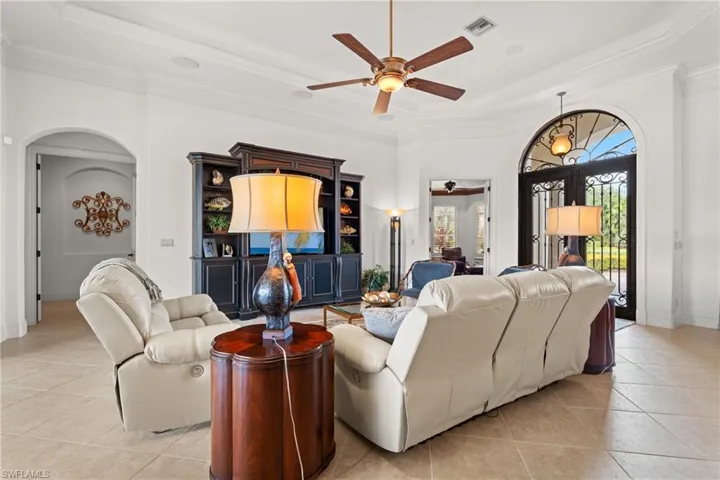 Living room featuring crown molding, light tile patterned floors, and a raised ceiling