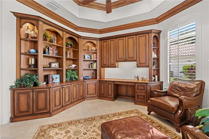Office featuring light tile patterned floors, ornamental molding, and built in desk