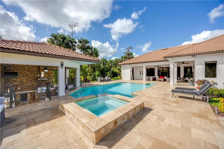 View of pool featuring an outdoor kitchen, a patio area, and a pool with connected hot tub