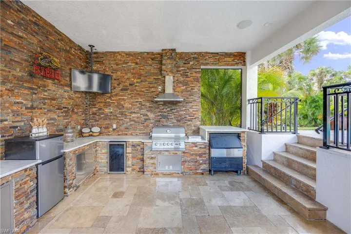 View of patio / terrace featuring an outdoor kitchen and beverage cooler