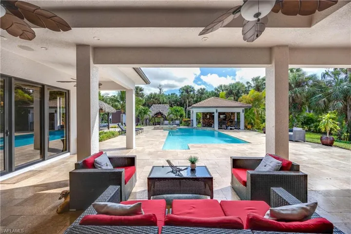 Outdoor pool with a patio area, an outdoor hangout area, a gazebo, and an outdoor structure