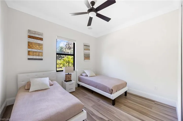 Bedroom with crown molding, ceiling fan, and wood finished floors