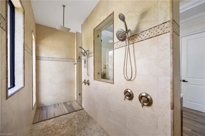 Full bath with a walk in shower and tile walls