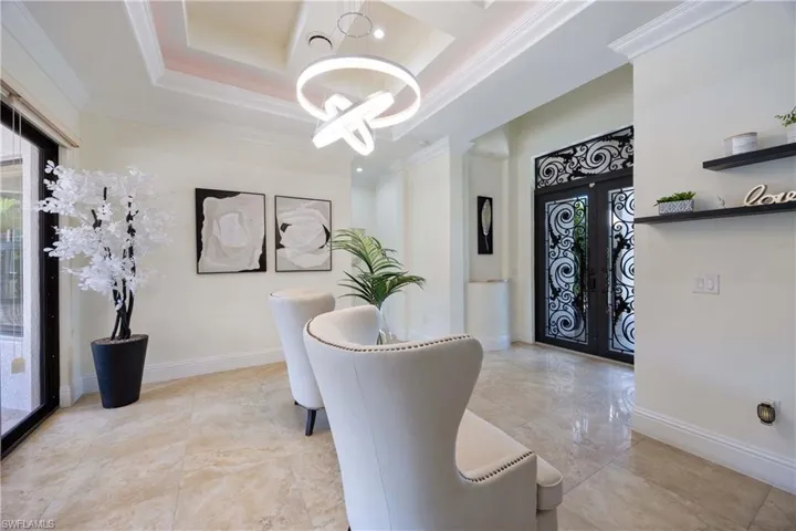 Office space with french doors, ornamental molding, a chandelier, and a raised ceiling