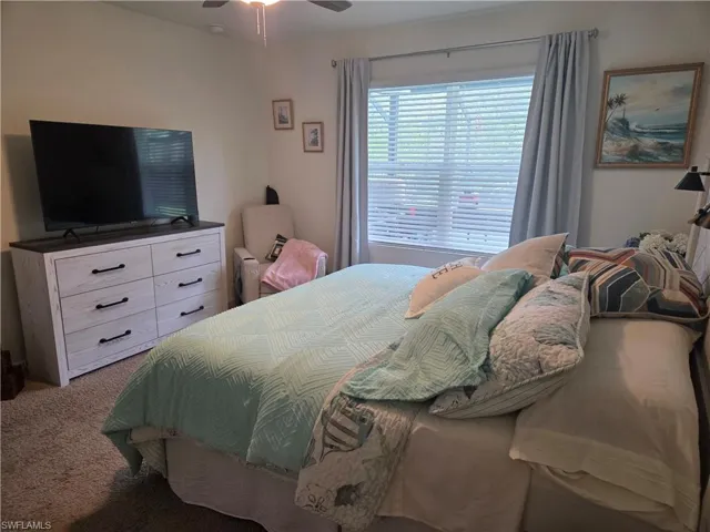 Carpeted bedroom featuring a ceiling fan
