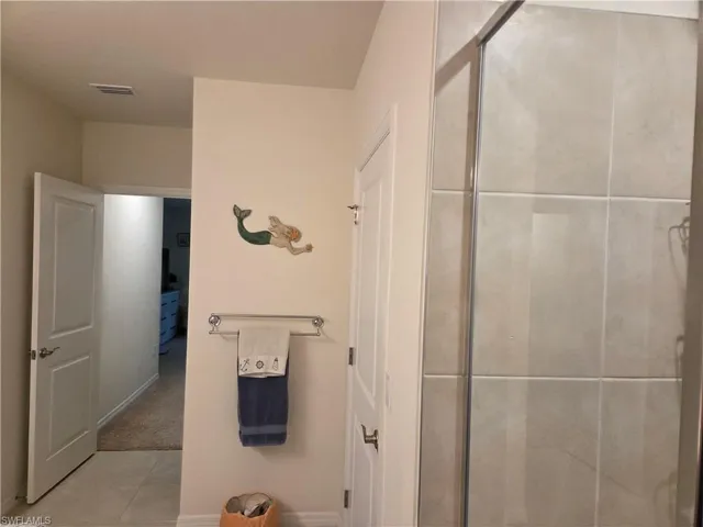 Bathroom featuring a tile shower and tile patterned flooring