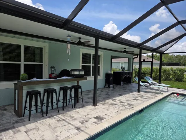 Swimming pool with a lanai, a patio area, and ceiling fan