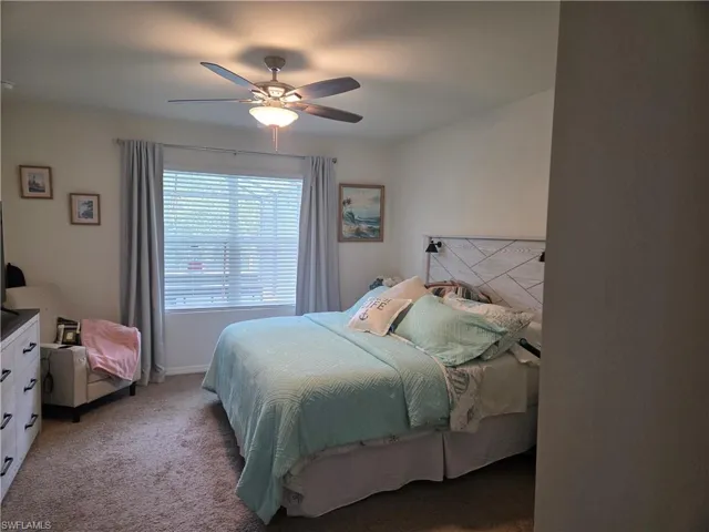 Bedroom with light colored carpet and ceiling fan