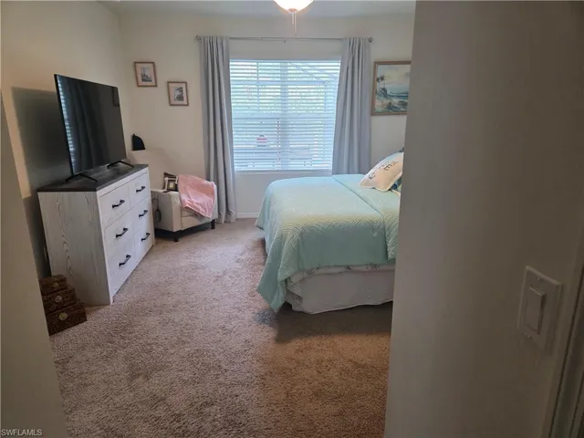 Bedroom featuring light carpet