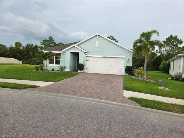 Ranch-style home featuring decorative driveway, a front yard, a garage, and stucco siding