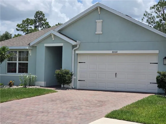 View of front of house featuring stucco siding, decorative driveway, and a garage