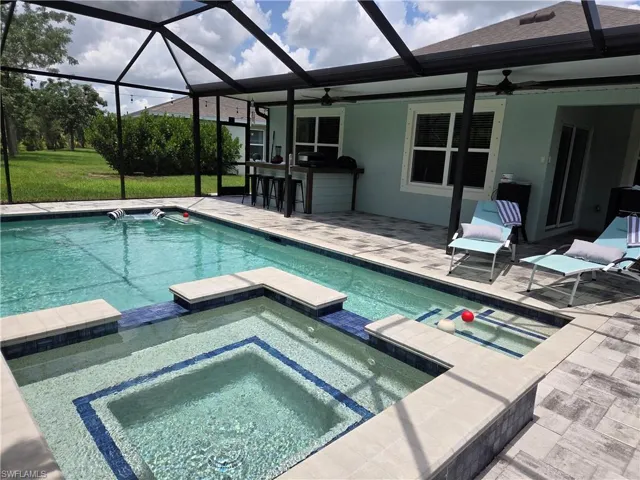 View of swimming pool with a pool with connected hot tub, a patio, and a ceiling fan