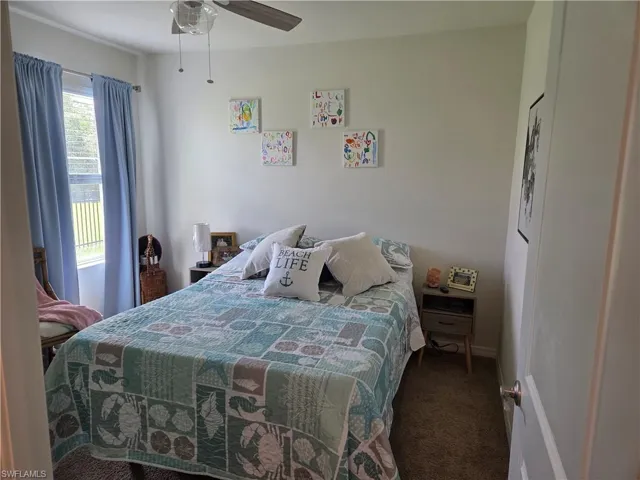 Carpeted bedroom with a ceiling fan