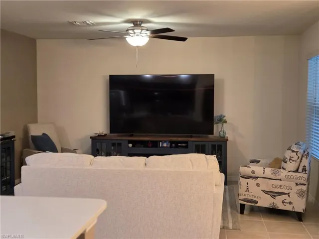 Tiled living area featuring ceiling fan