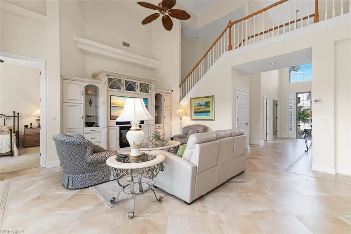 Living area featuring a high ceiling, a ceiling fan, and light tile patterned floors