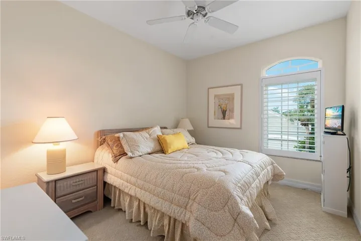 Bedroom with light carpet and a ceiling fan