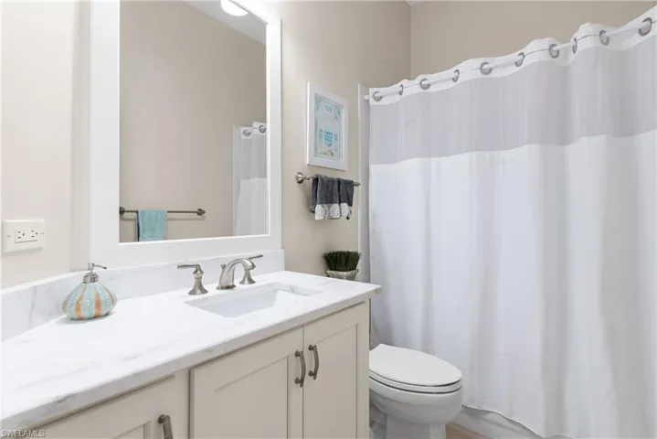 Bathroom with a shower with shower curtain and vanity