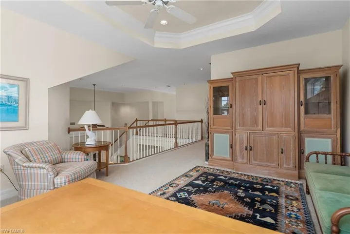 Sitting room with an upstairs landing, crown molding, a tray ceiling, and carpet floors