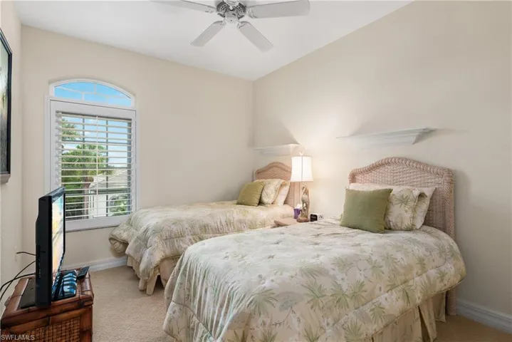 Bedroom with a ceiling fan and carpet