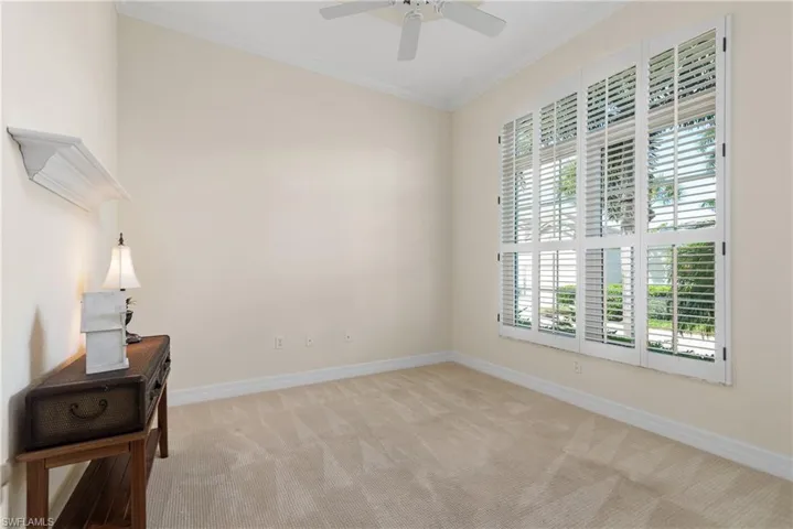 Spare room with crown molding and light carpet