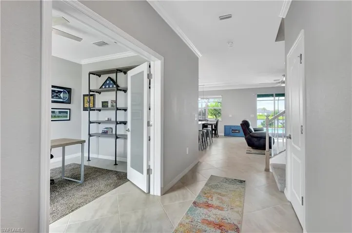 Corridor with ornamental molding and light tile patterned floors