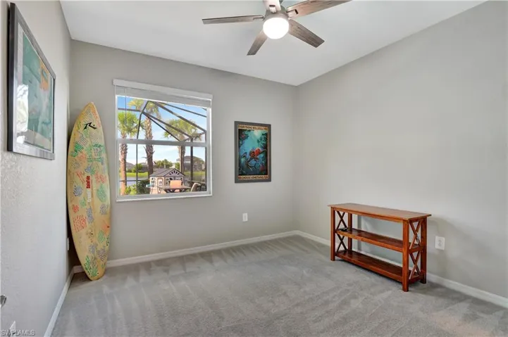 Empty room featuring light colored carpet and ceiling fan