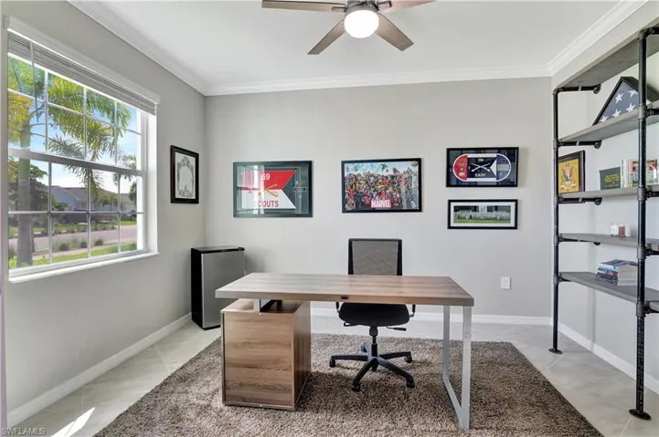 Office with light tile patterned flooring, ceiling fan, and ornamental molding