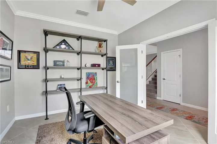 Home office featuring ornamental molding, light tile patterned floors, and ceiling fan