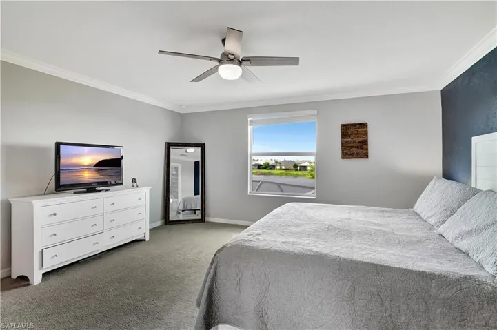 Bedroom featuring ornamental molding, carpet flooring, and ceiling fan