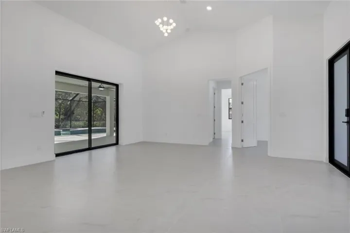 Unfurnished room with lofted ceiling, a sunroom, and hanging lights