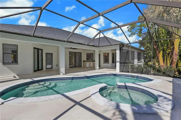 Integrated pool / spa with a sunroom, a lanai, and a patio