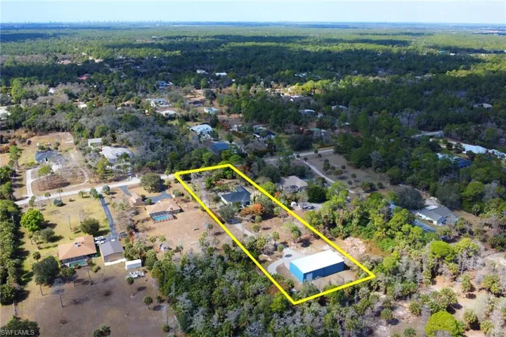 Aerial view of property's location featuring property parcel outlined and a forest