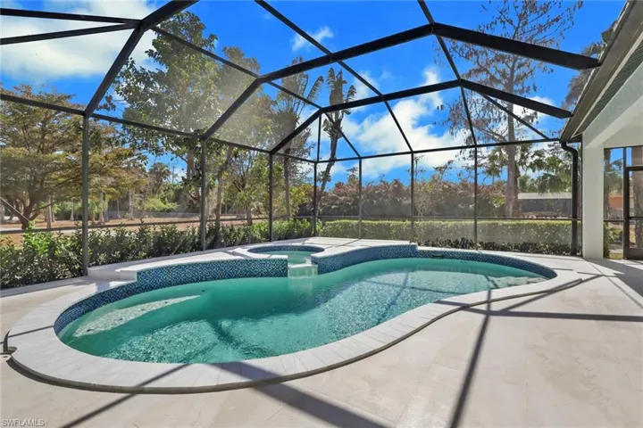 Integrated pool / spa featuring a sunroom, glass enclosure, and a patio area