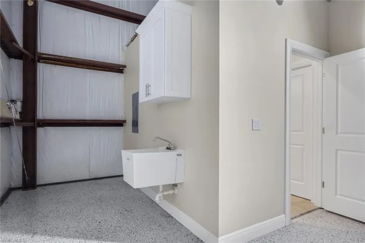 Laundry area featuring dark speckled floor and electric panel
