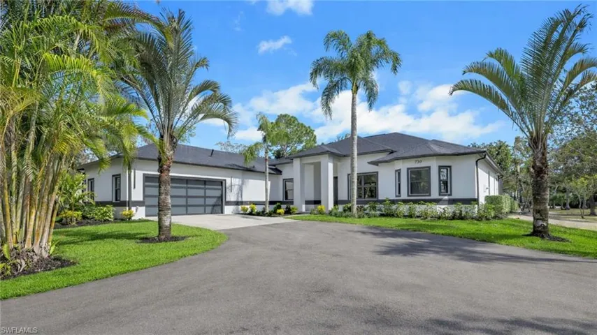 Virtually Staged View of front of home with stucco siding, an attached garage, asphalt driveway, and a front yard