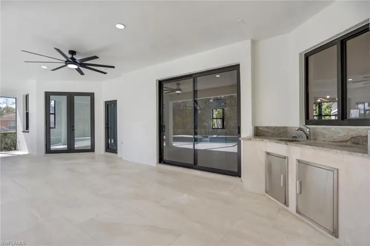 View of patio featuring an outdoor kitchen, a ceiling fan, and french doors