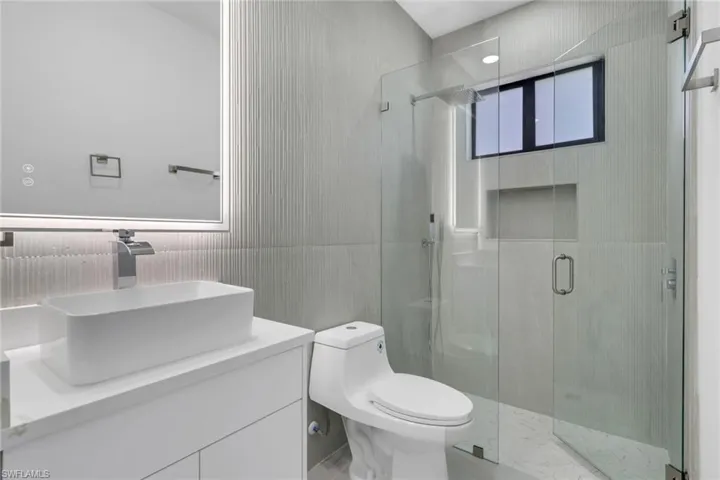 Bathroom with a stall shower, a soaking tub, healthy amount of natural light, and marble tiled flooring