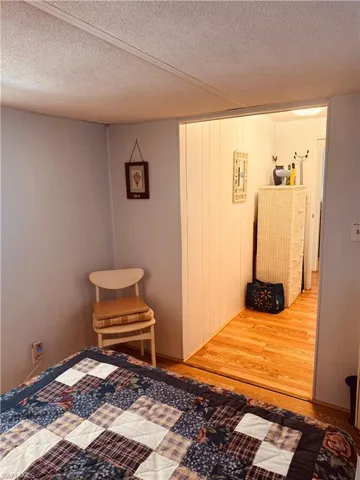 Bedroom with a textured ceiling and light wood-style floors
