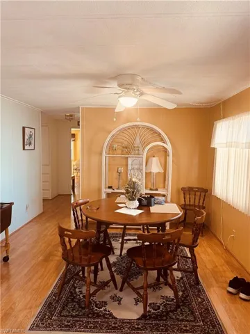 Dining space with a ceiling fan and light wood-type flooring