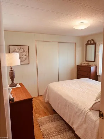 Bedroom with wood finished floors and a textured ceiling
