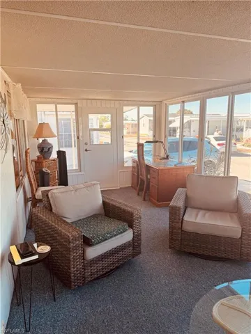 Sunroom / solarium with a textured ceiling and carpet