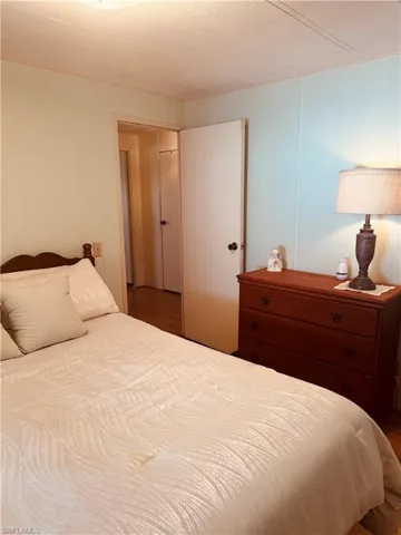 Bedroom featuring a decorative wall and wood finished floors