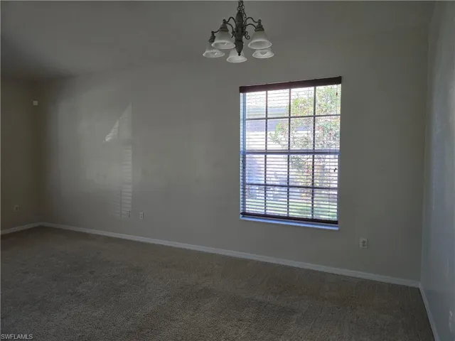 Carpeted Family room featuring baseboards and a chandelier