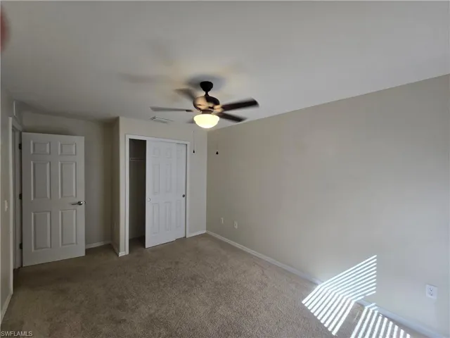 Unfurnished bedroom with carpet floors, a closet, and ceiling fan