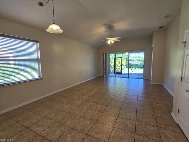 Living room with plenty of natural light, lofted ceiling, tile patterned flooring, and a ceiling fan